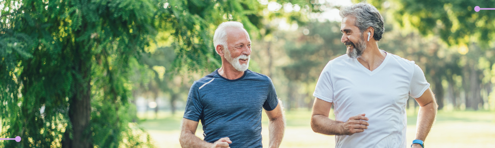 Pair of older adult men jogging in a local park.
